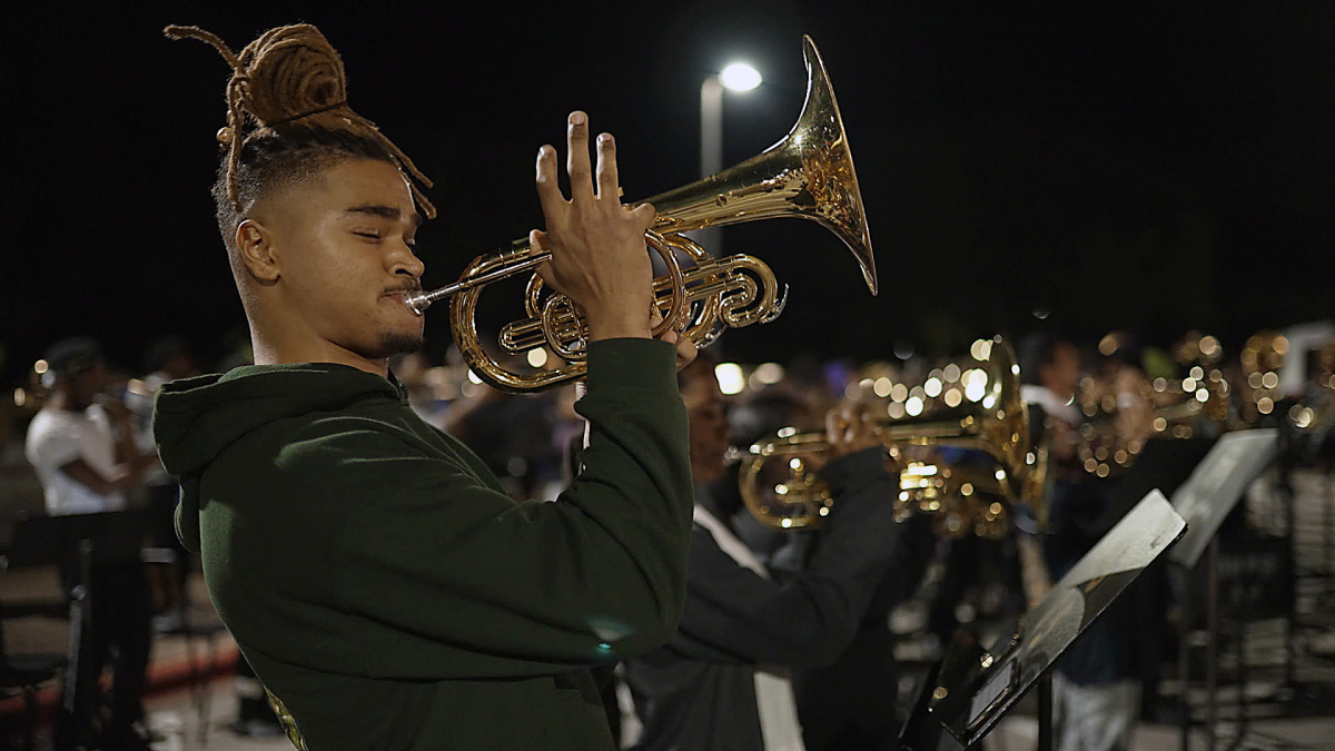 student playing trumpet in college marching band